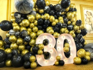 Стена из шаров в черно золотом цвете с цифрами